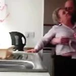 Elderly couple affair in kitchen.