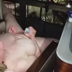 Elderly woman exposed masturbating, night, window view.